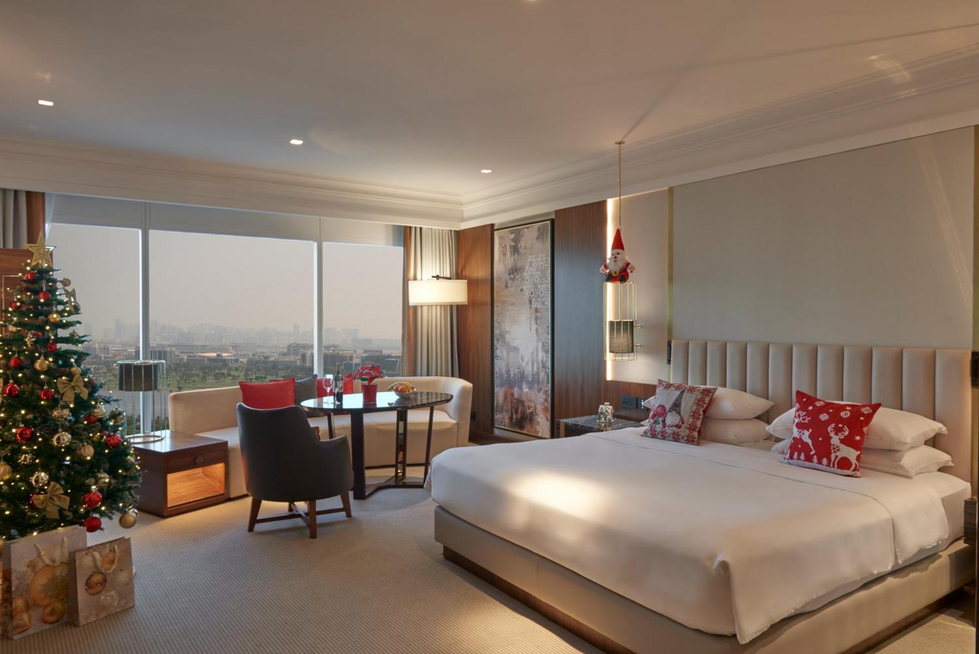 Hotel Grand Hyatt Dubai Camera foto The photo depicts a modern hotel room. It features a spacious layout with a large bed placed against a headboard. The bedding includes decorative pillows. To one side, there's a seating area with a small table and two chairs, ideal for lounging. A Ch