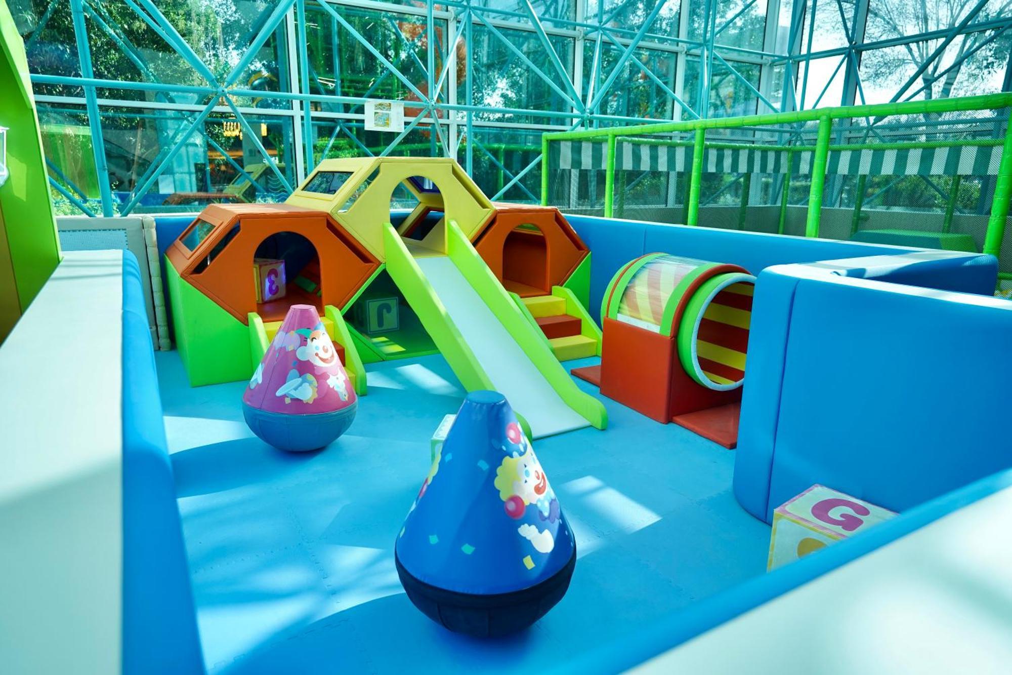 Hotel Grand Hyatt Dubai Esterno foto The photo shows a colorful indoor play area designed for young children. It features various play structures, including a small slide, climbing structures shaped like hexagons, and a tunnel. There are also large, soft, rounded toys in vibrant colors,