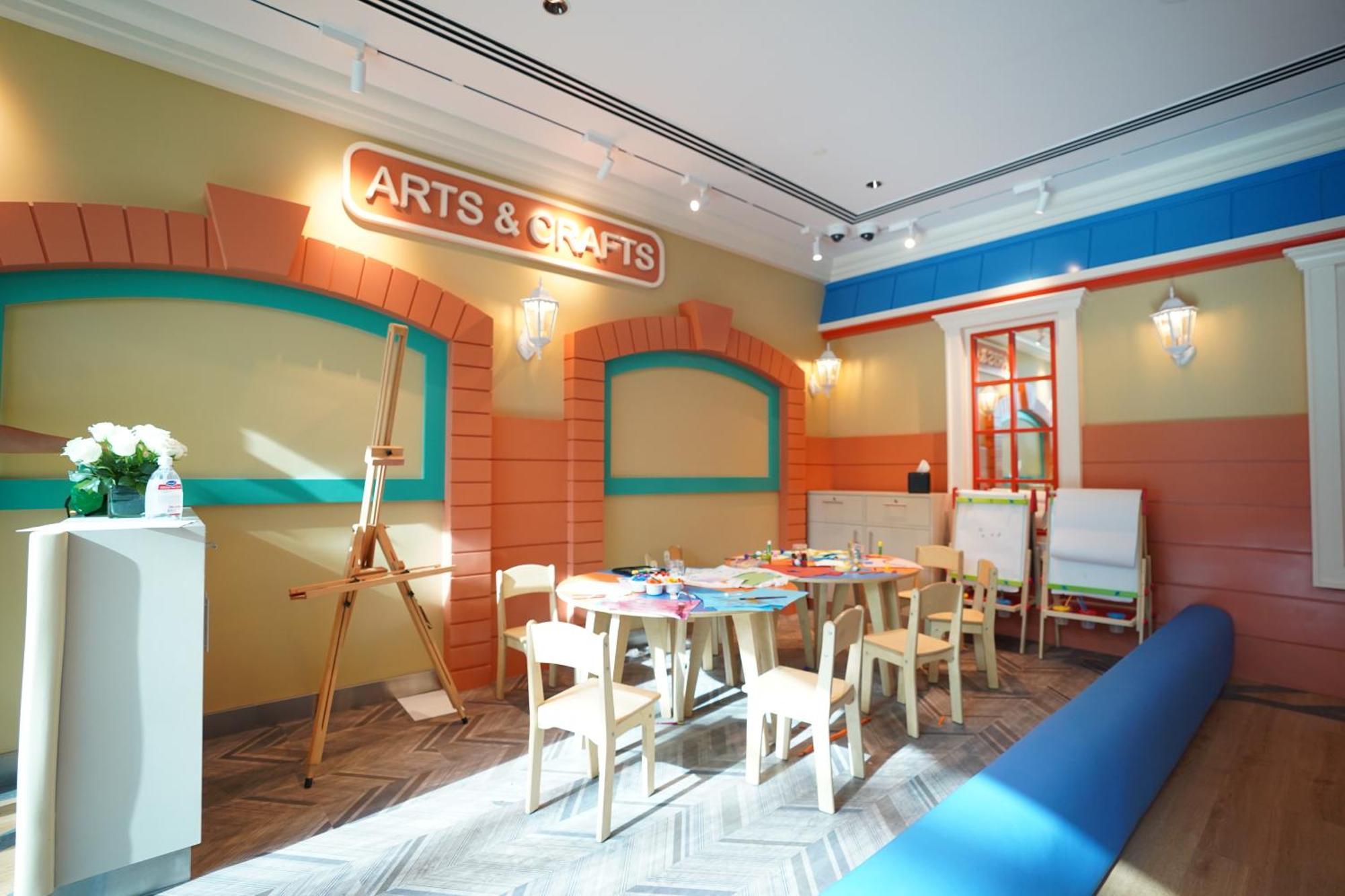 Hotel Grand Hyatt Dubai Esterno foto The photo shows a brightly colored arts and crafts room. The walls are painted in warm shades with decorative elements, including an "ARTS & CRAFTS" sign prominently displayed. There is a large wooden easel, indicating space for creative activities, 