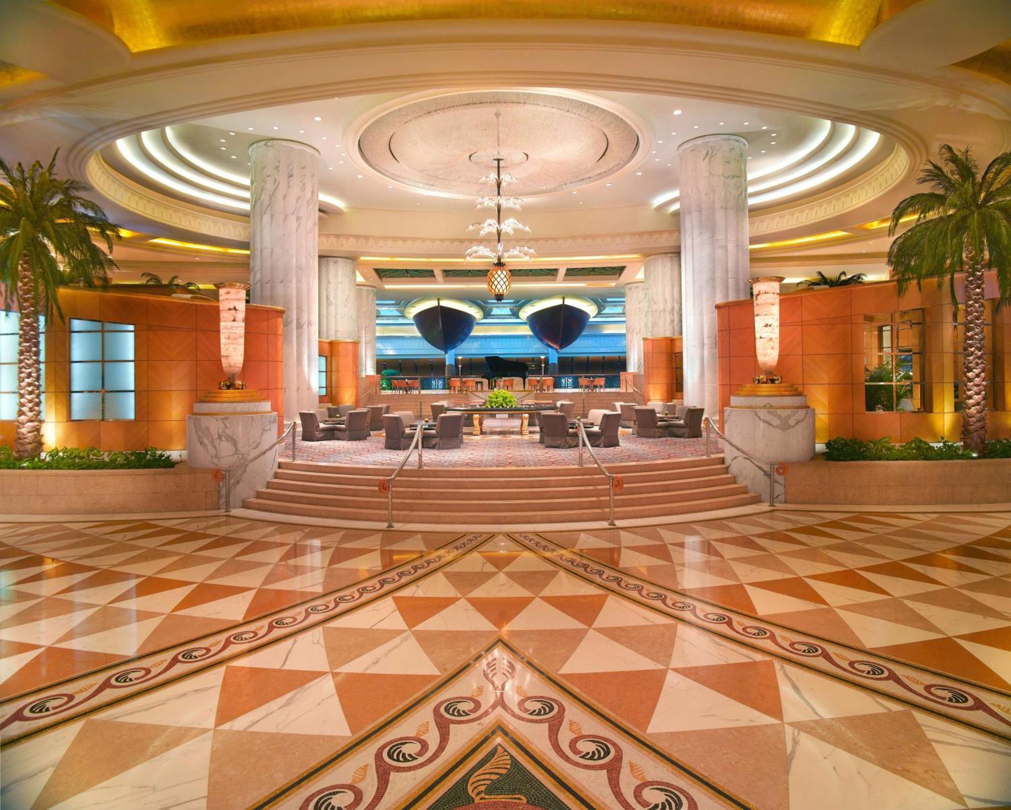 Hotel Grand Hyatt Dubai Esterno foto The photo depicts a luxurious hotel lobby. The space features high ceilings with elegant lighting and intricate architectural details. Tall columns stand prominently, and there are stylish seating arrangements visible. The floor is adorned with a geo
